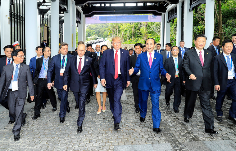 Image: Presidents Trump and Putin walk together with Vietnamese President Tran Dai Quangat the APEC summit on Saturday