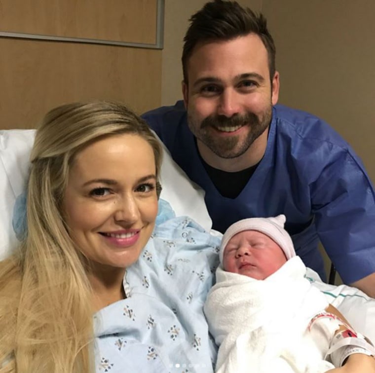 Emily Maynard and her husband Tyler Johnson pose with their new little boy.