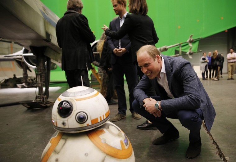 Britain's Prince William, Duke of Cambridge smiles at BB-8 droid during a tour of the Star Wars sets at Pinewood studios in Iver Heath, west of London on April 19, 2016.