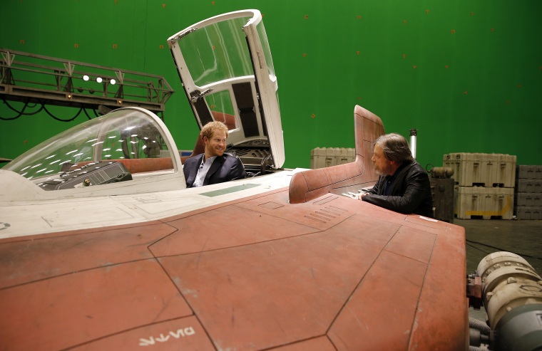 Britain's Prince Harry sits in an A-wing fighter as he talks with US actor Mark Hamill during a tour of the Star Wars sets at Pinewood studios in Iver Heath, west London, Tuesday April 19, 2016.