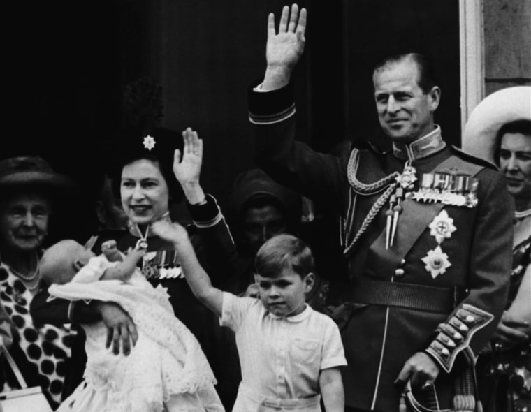 Queen Elizabeth II holds her 12 week old son, Prince Edward, as she stands with her husband Prince Phillip on the balcony of Buckingham Palace on June 13, 1964. (AP photo)