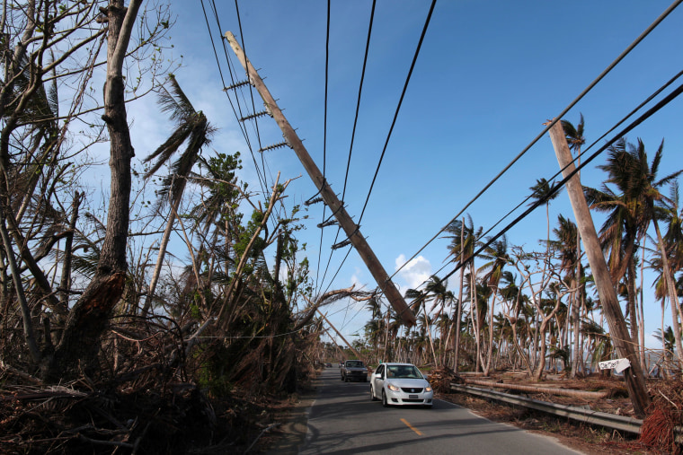 Image:Cars drive under a partially collapsed utility pole, after the island was hit by Hurricane Maria in September, in Naguabo