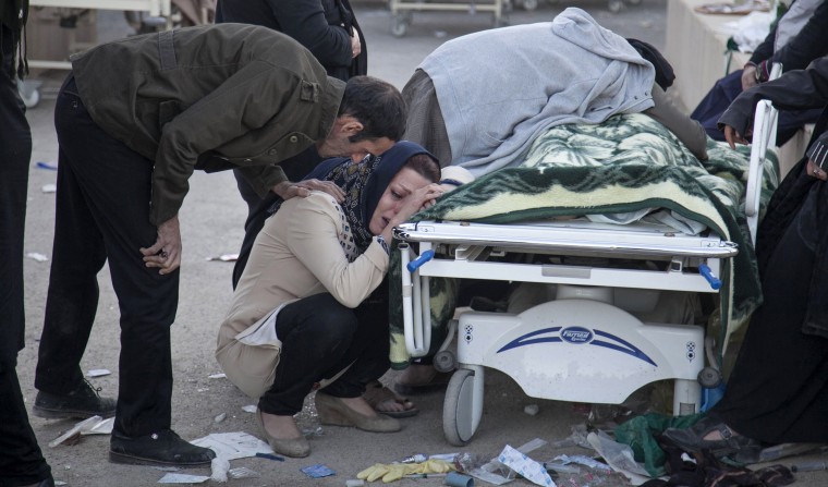 Image: Relatives weep over the body of an earthquake victim