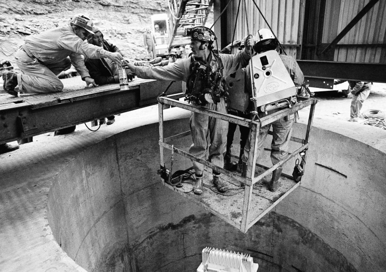 Image: A rescue worker grabs a last piece of equipment before heading into the Scotia Mine on March 12, 1976