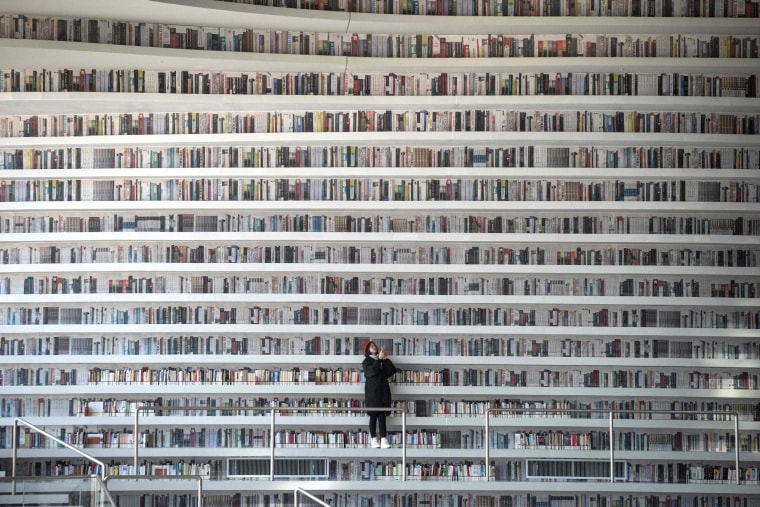 Image: A woman taking pictures at the Tianjin Binhai Library