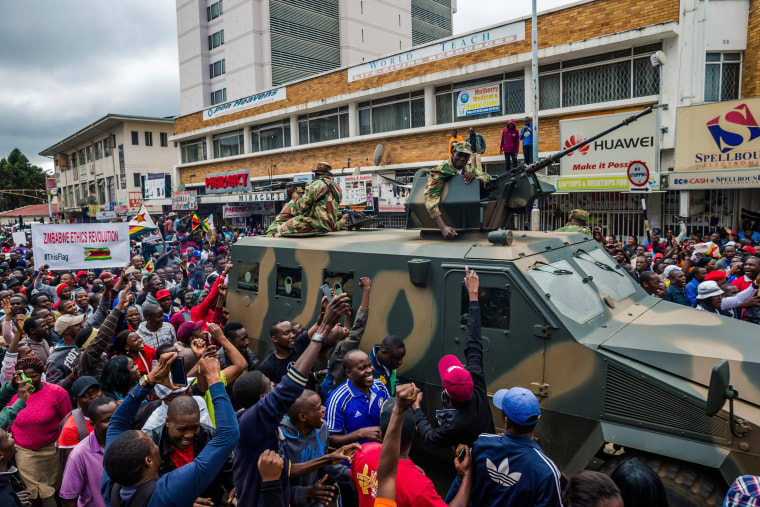 Image: People cheer a passing Zimbabwe military vehicle