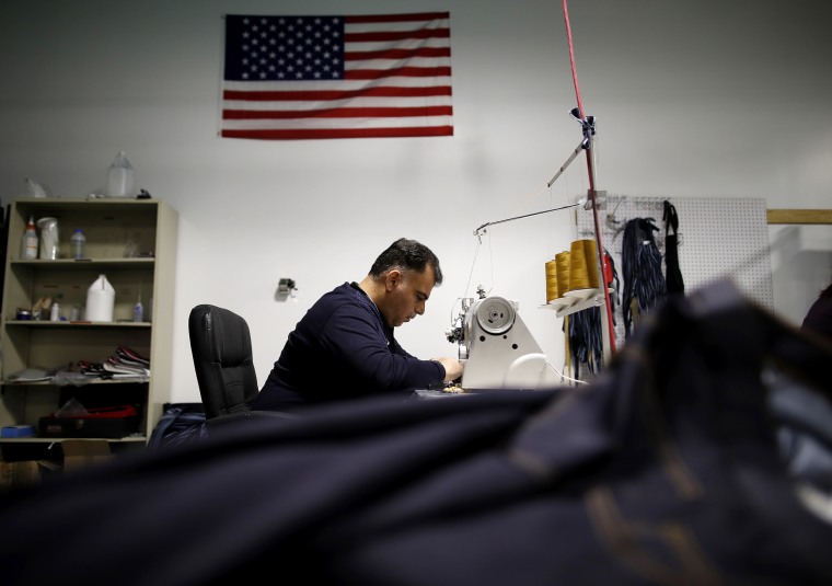 Image: An employee operates a sewing machine to stitch a pair of jeans at the Dearborn Denim facility in Chicago
