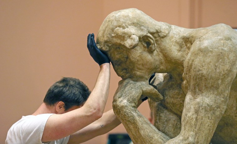 Image: A worker moves a rare plaster cast of Rodin's \"The Thinker\"