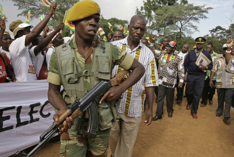 A soldier closely guards Mugabe, in red cap, upon his arrival at a rally in Mubayira, south of Harare, on March, 13, 2008.
The country hit rock bottom in 2008, when 500 billion percent inflation drove people to support the challenge of Western-backed former union leader Morgan Tsvangirai.
Facing defeat in a presidential run-off, Mugabe resorted to violence, forcing Tsvangirai to withdraw after scores of his supporters were killed by ZANU-PF thugs.