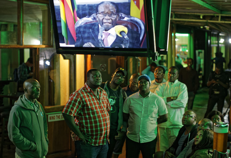 Image: Zimbabweans watch a televised address to the nation by President Robert Mugabe at a bar