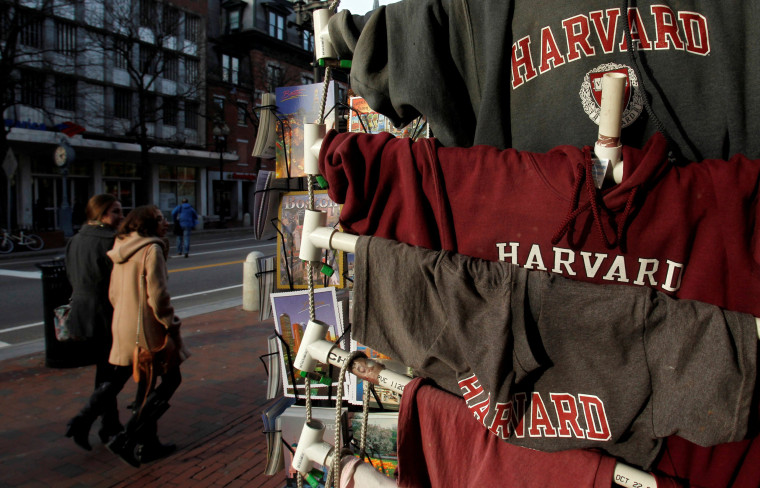 Image: People walk past Harvard University t-shirts for sale in Harvard Square in Cambridge