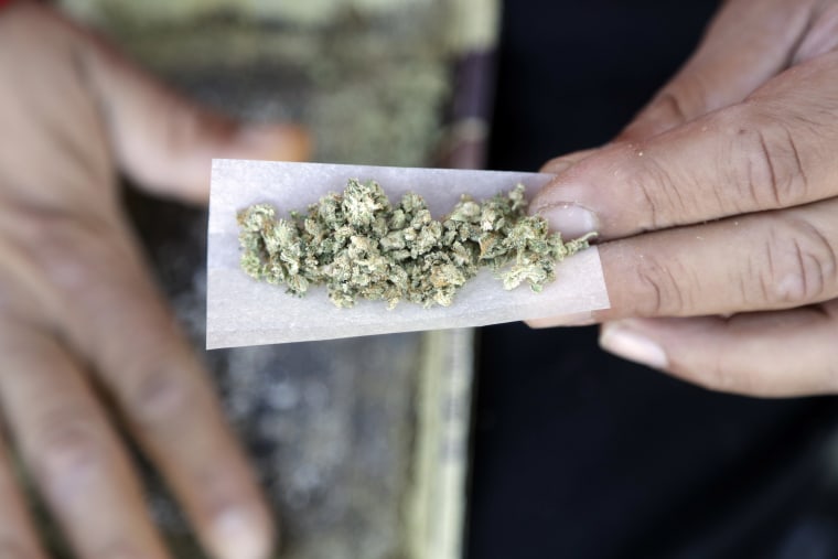 Image: A man rolls a marijuana joint is in San Francisco.