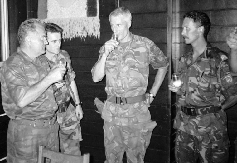 Image: Ratko Mladic, left, drinks a toast with Dutch U.N. Commander Tom Karremans