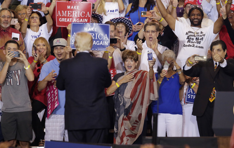Image: Trump turns to the crowd while speaking at a rally in Phoenix