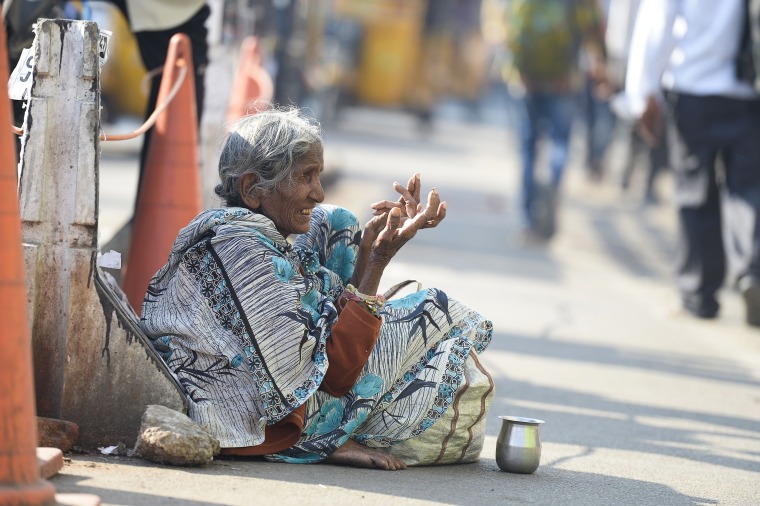 Image: A woman begs on the side of a road in Hyderabad, India