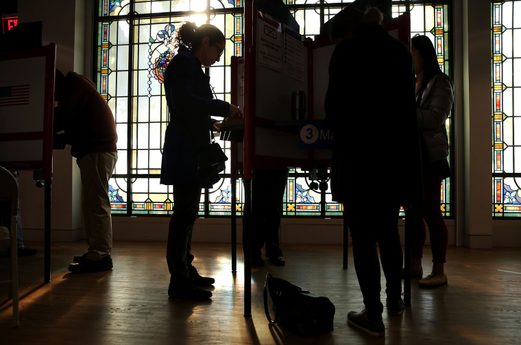 Image: Voters fill out their paper ballots in a polling place on election day