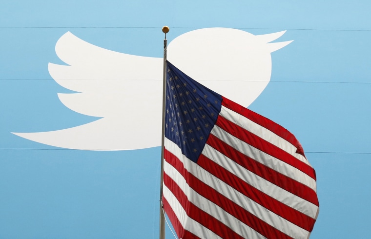 Image: The Twitter Inc. logo is shown with the U.S. flag during the company's IPO on the floor of the New York Stock Exchange in New York