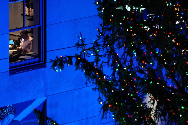 Image: A person works in the office during the Christmas tree lighting ceremony at Rockefeller Center in the Manhattan borough of New York City