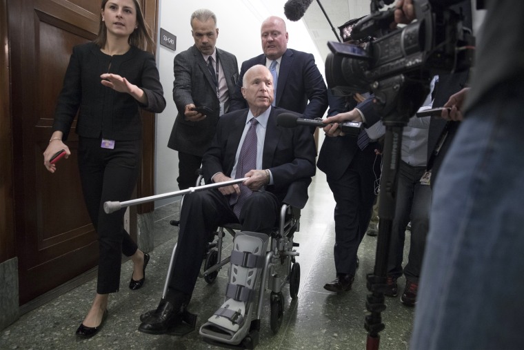 Image: Members of the media follow Senator John McCain following an Armed Services Committee hearing on Capitol Hill