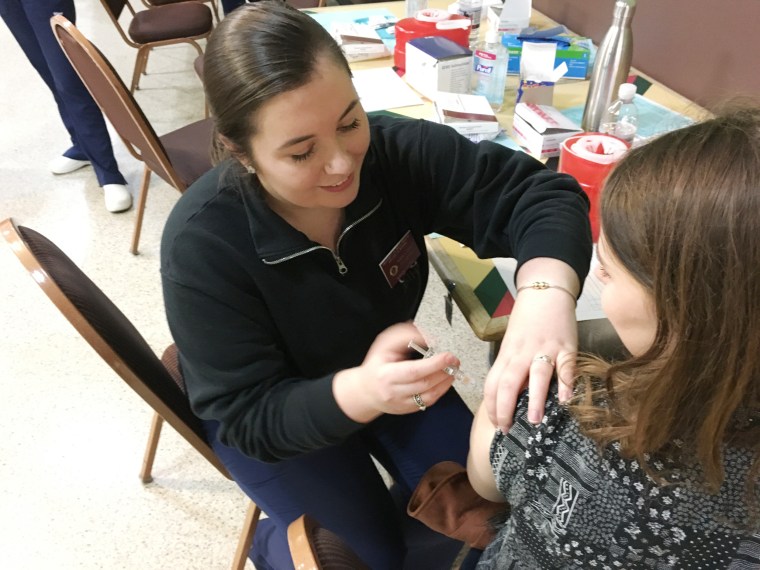 Image: Karly Fitzgerald, 22, a nursing student, administers a Meningitis B vaccine