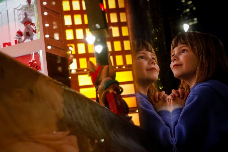 Image: A child looks at the decorated holiday windows at Macy's department store in New York City