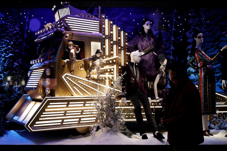 Image: People look at a Christmas holiday window display outside the Printemps department store in Paris