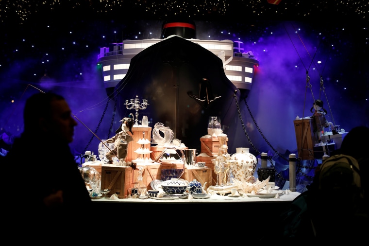 Image: People look at a Christmas holiday window display outside the Printemps department store in Paris