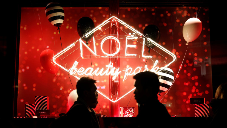 Image: People walk past a Christmas holiday window display outside a Sephora store in Paris