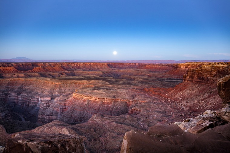 Image: A full moon sets behind Cedar Mesa, which is within Bears Ears National Monument, near Mexican Hat