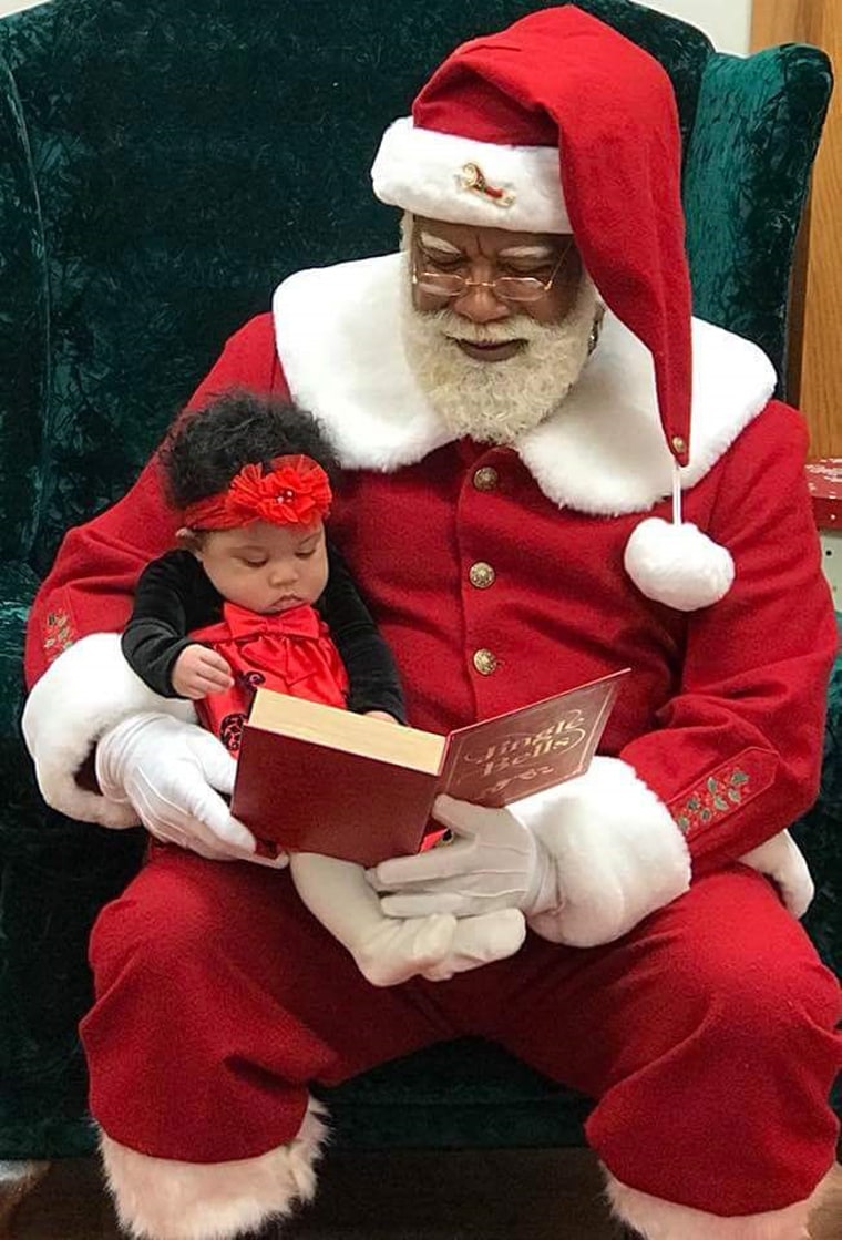 Image: Larry Jefferson sits with a child during a mall Santa Claus photo shoot.