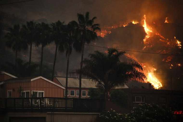 Image: A wildfire threatens homes as it burns along a hillside in La Conchita
