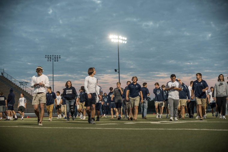 Image: Kingwood players walk on the field to suit up before the game