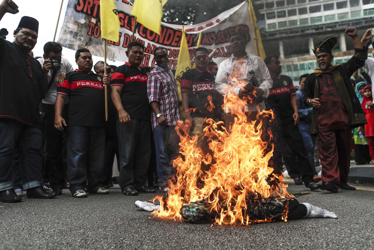 Image: Protesters burn an effigy of Trump in front of the U.S. Embassy in Kuala Lumpur.
