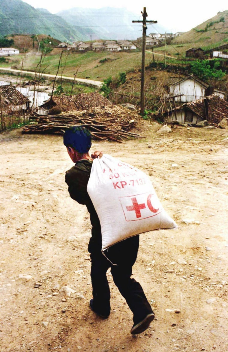 Image: A North Korean carries a sack containing Red Cross rations in 1997
