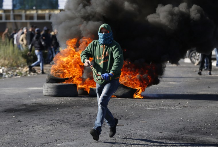 Image: A Palestinian armed with a slingshot attends a protest in Ramallah
