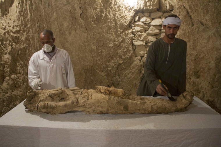 Image: Egyptian excavation workers restore a mummy in a newly discovered tomb on Luxor's West Bank known as "KAMPP 150" during an announcement for the Egyptian Ministry of antiquities about new discoveries in Luxor, Egypt, Dec. 9, 2017.