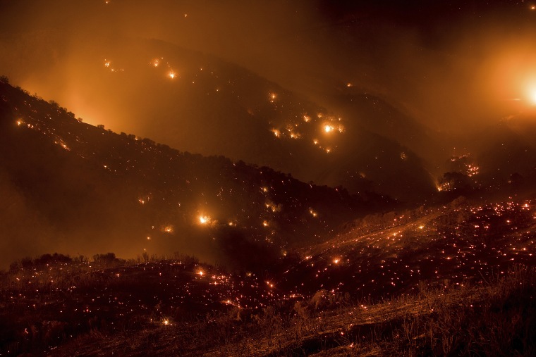 Image: A hillside glows with embers as the Thomas fire burns through Los Padres National Forest