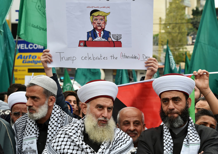 Image: A protester carries a sign against Trump's decision to recognize Jerusalem