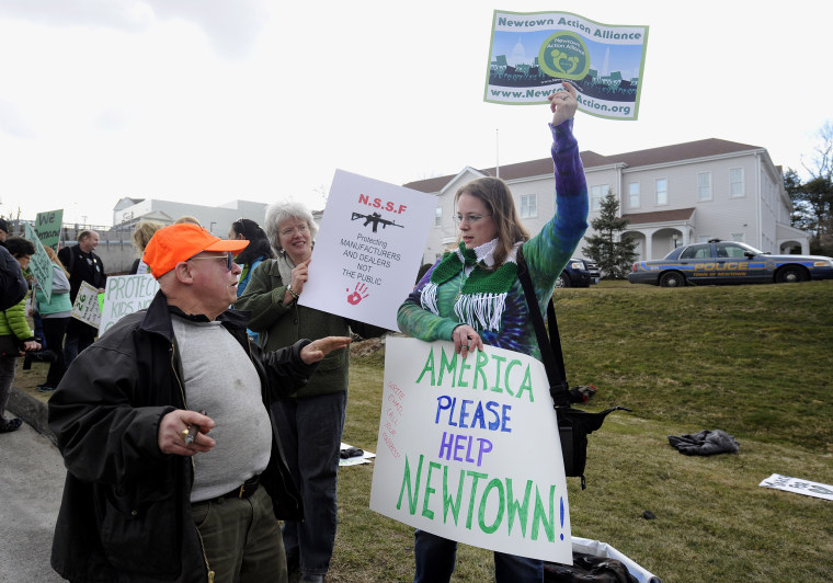 Image: Phillip W. Mauriello of Watertown, Connecticut, left, who is not in favor of any changes to gun laws in Connecticut speaks with Erin Nikitchyuk of Sandy Hook