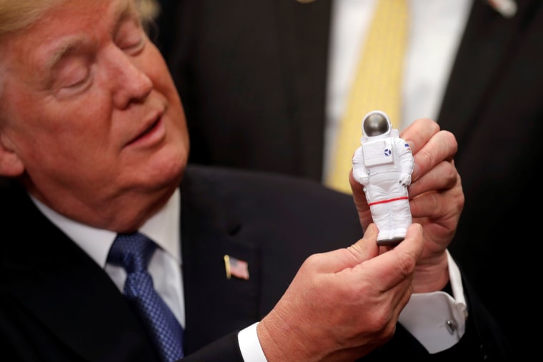 Image: U.S. President Donald Trump holds a space astronaut toy as he participates in a signing ceremony for Space Policy Directive at the White House in Washington D.C.