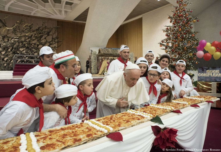 Image: Pope Francis blows out a candle on a pizza on Dec. 17, 2017 during an audience with children assisted by \"Dispensario Santa Marta\", a Vatican pediatric clinic at the Vatican. Pope Francis is celebrating his 81st birthday.