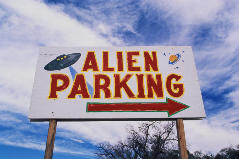 Image: This is a road sign indicating where Alien Parking is. This is the original UFO crash site in Roswell. There are small UFOs on the sign with a large arrow pointing to the right.