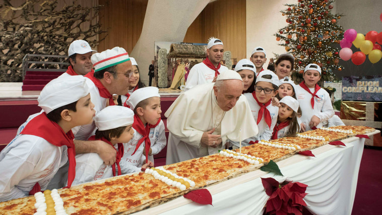 Image: Pope Francis blows on a cake to celebrate his birthday during a special meeting at Paul VI hall at the Vatican