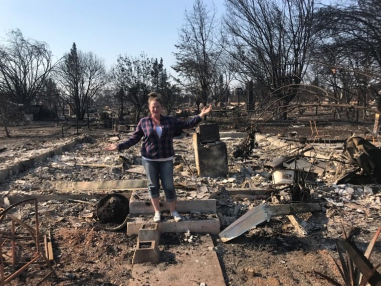 Lilly's mom, Jessica Biagini, stands among what's left after their home burned down in an October wildfire.