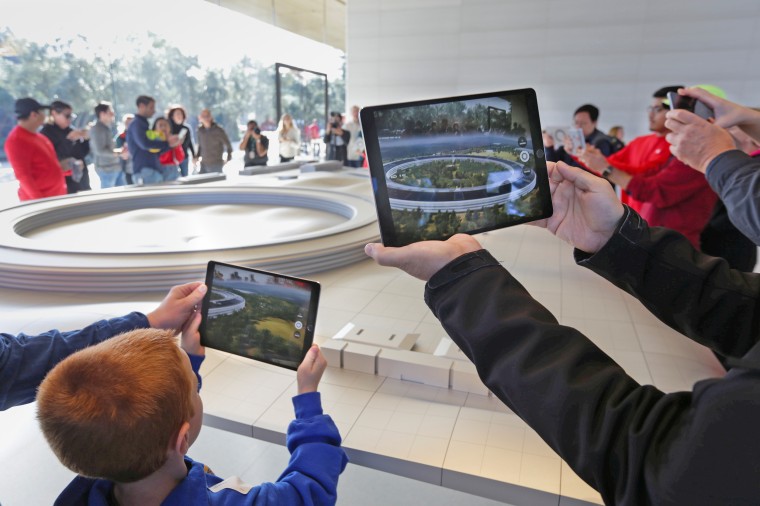 Visitors use iPads with augmented reality apps on them to discover features of the new Apple Park at the Apple Visitor Center in Cupertino