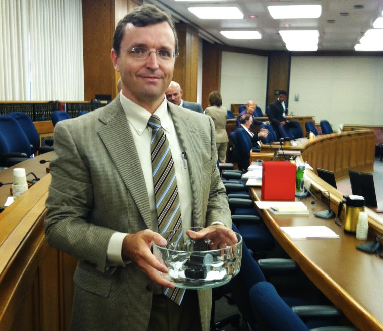 Matt Abell, Lead SBE Election Administration Analyst, holds the crystal bowl from which the political party slips were drawn at the June 26 board meeting.