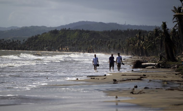 Image: Tourists wade in the water along the beach in the Punta Santiago beachfront neighborhood in Humacao