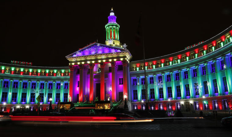 Image: Motorists pass the traditional holiday light display illuminates the Denver City/County Building