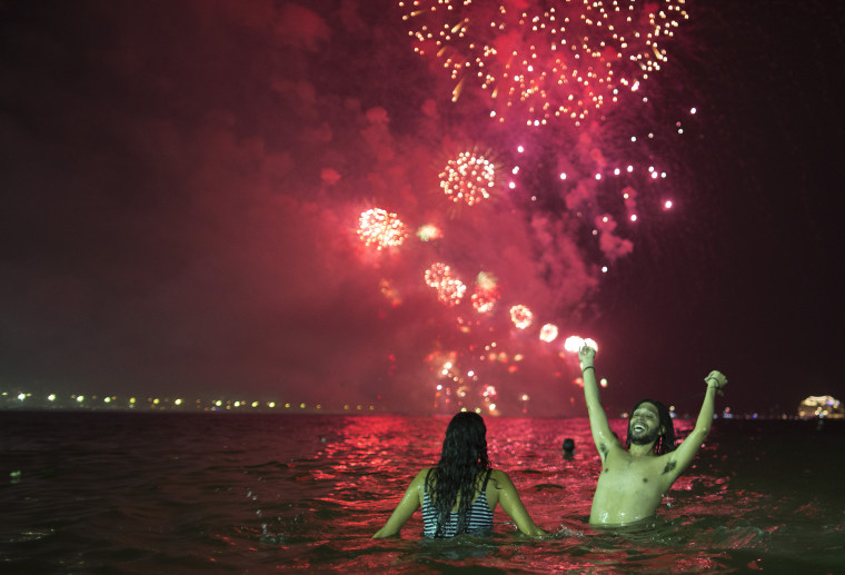People watch the fireworks exploding over Copacabana beach during the New Year's Eve celebrations in Rio de Janeiro, Brazil, Sunday, Jan. 1, 2017.