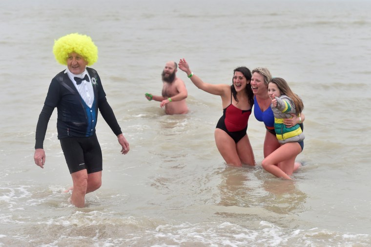 Image: Revellers take part in a New Year's dive in Ostend